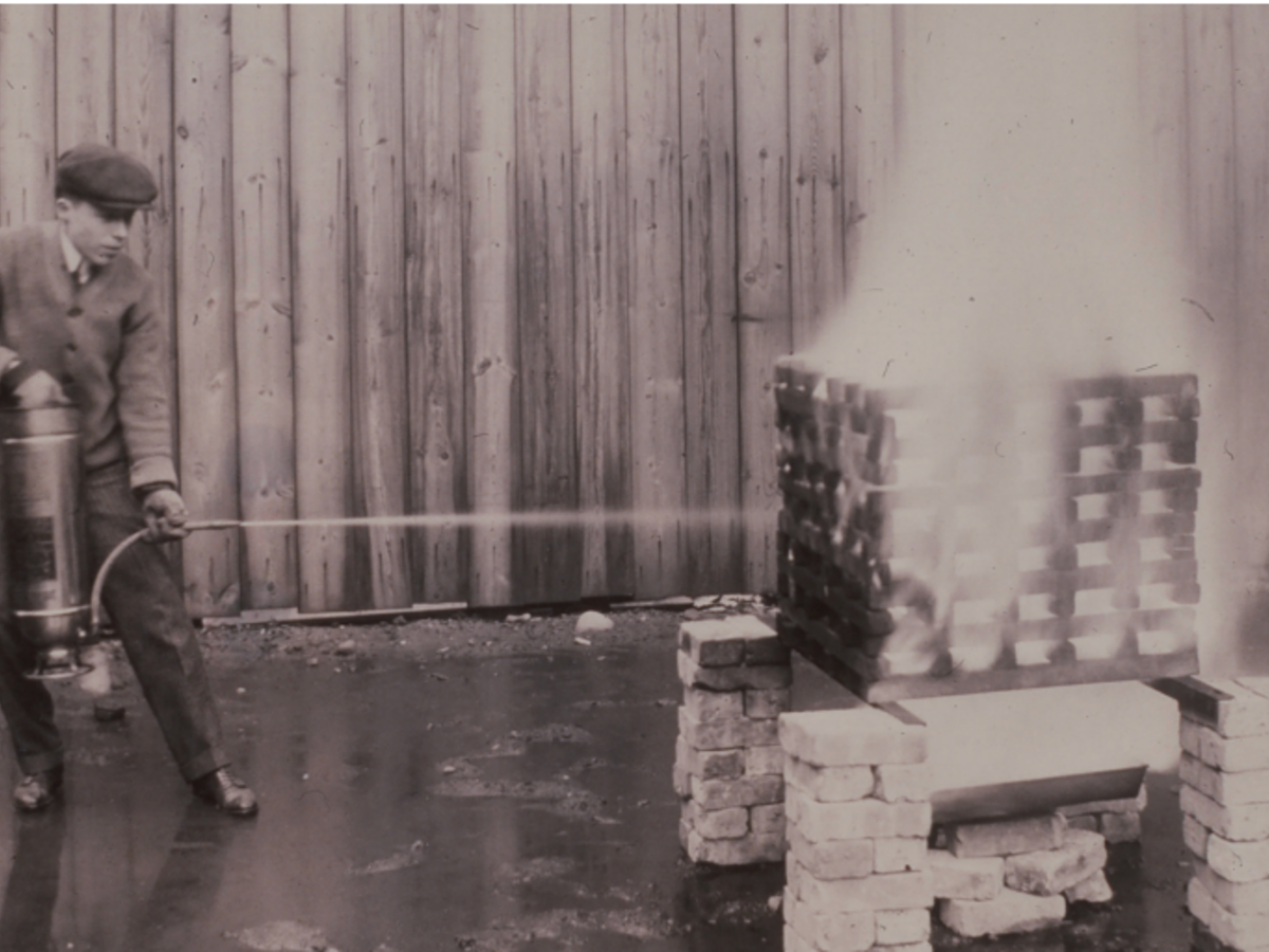 A soda acid fire extinguisher undergoing testing at Underwriters Laboratories, circa 1910s. These extinguishers were the first UL-labeled devices. 
