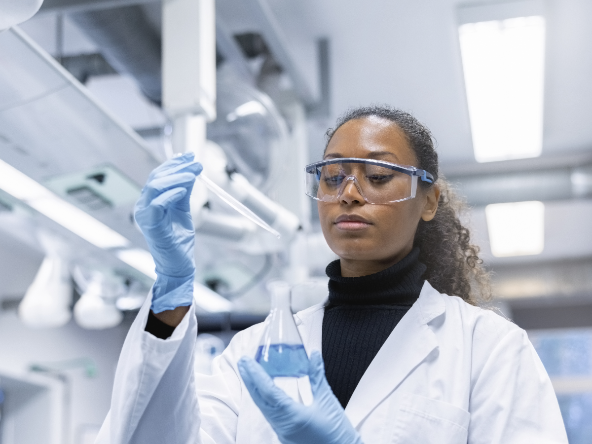 black female scientist with chemical in flask