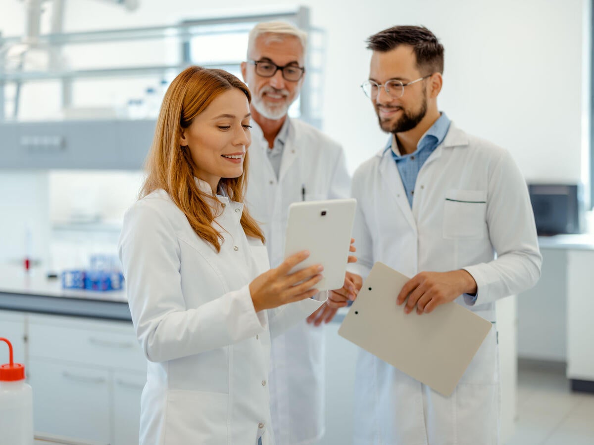 Modern Medical Research Laboratory: Science Research, Work and People Concept - Team of Scientists With Tablet Pc Computer Working in Laboratory