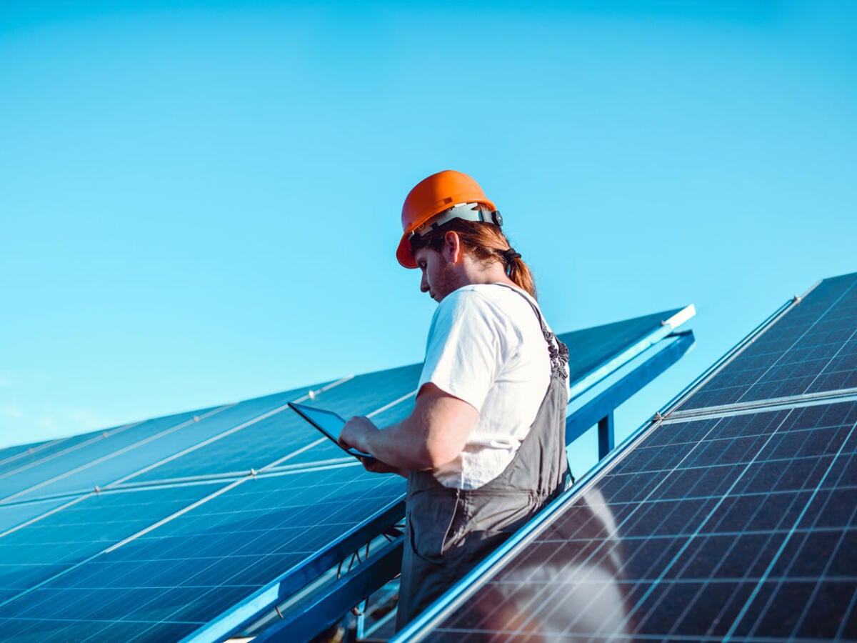Person looking at a tab near solar panel
