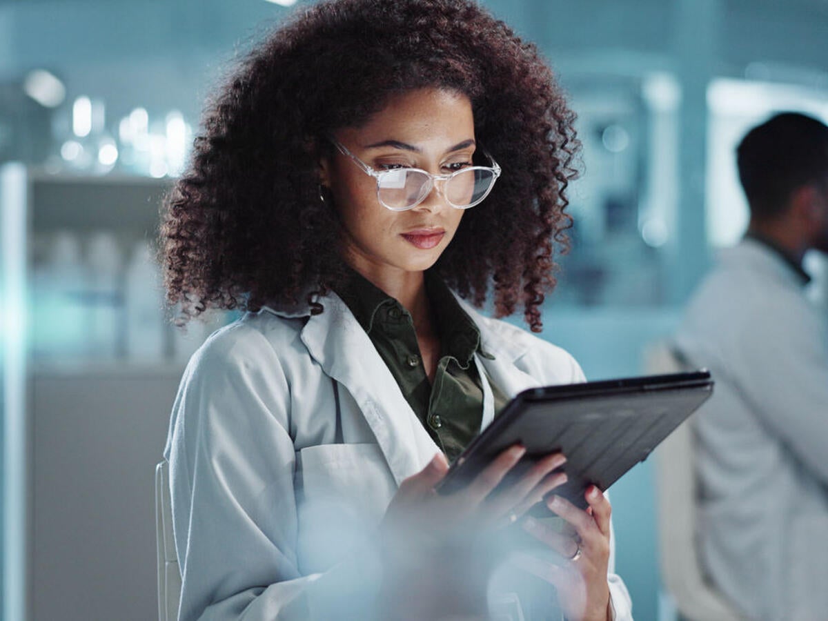 Tablet, reading and woman scientist in laboratory working on medical research, project or experiment. Science, career and female researcher with digital technology for pharmaceutical innovation.