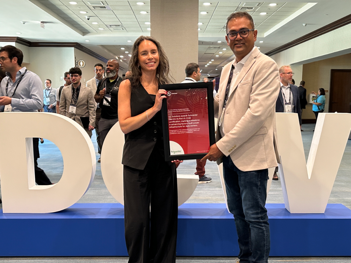 Chante Maurio, VP of Data Centers, presents Manav Patel, VP of Strategy and Transformation with a red framed certificate at Data Center World Power on Sept. 22, 2026