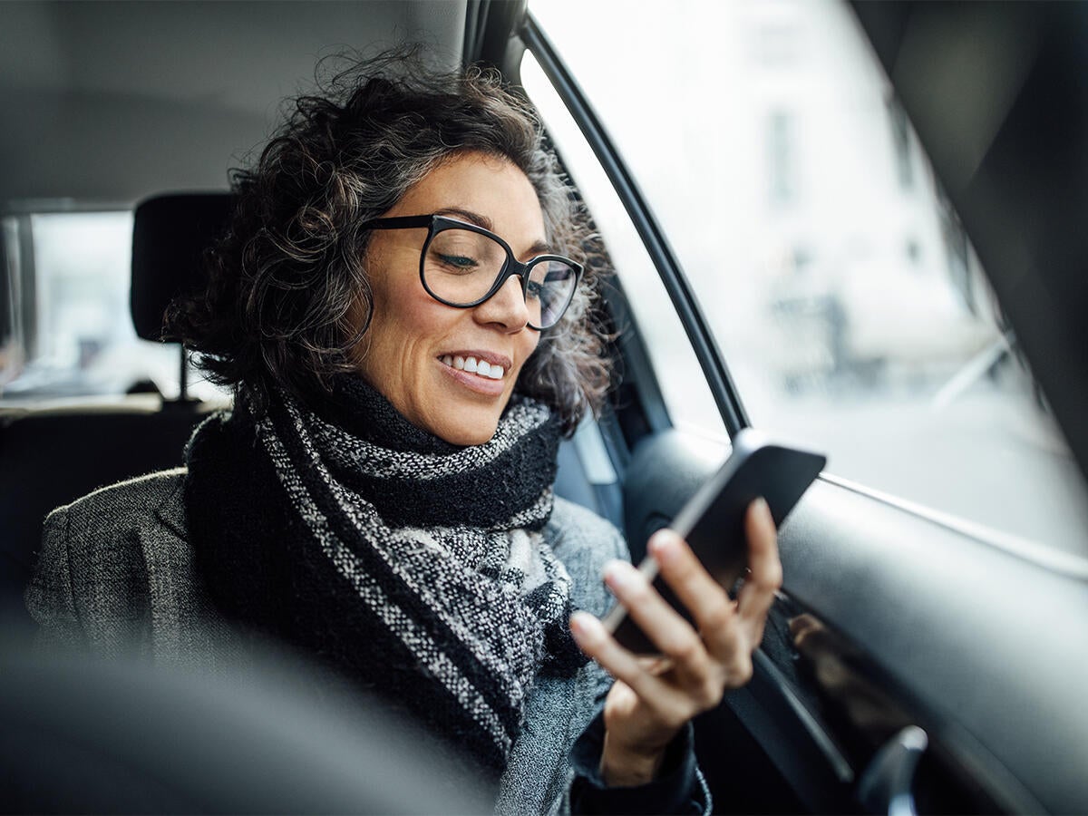 woman in car looking at phone