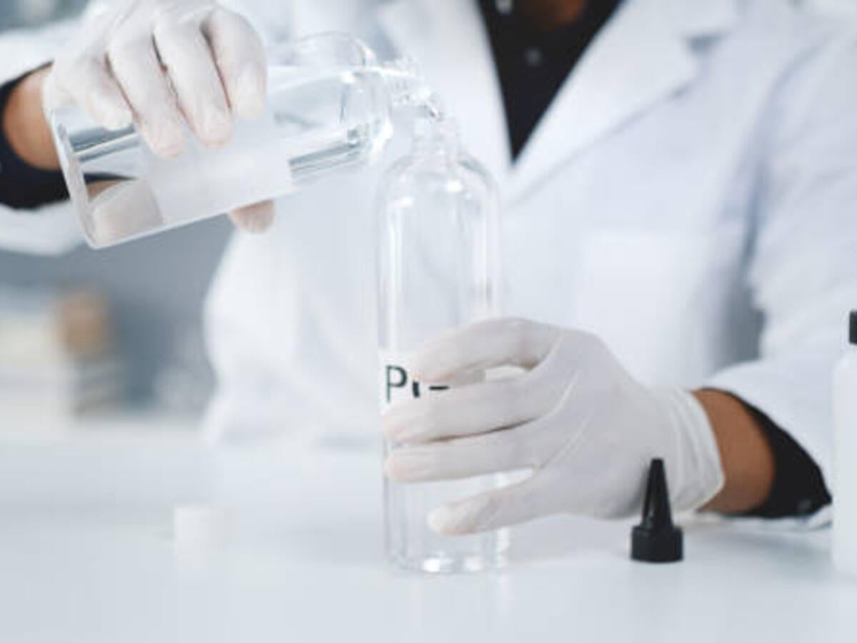 Person pouring liquid into a bottle 
