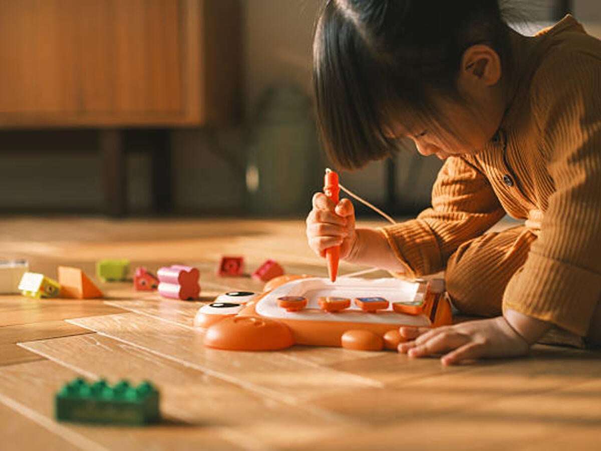 Toddler drawing on a magnetic drawing board on the floor 