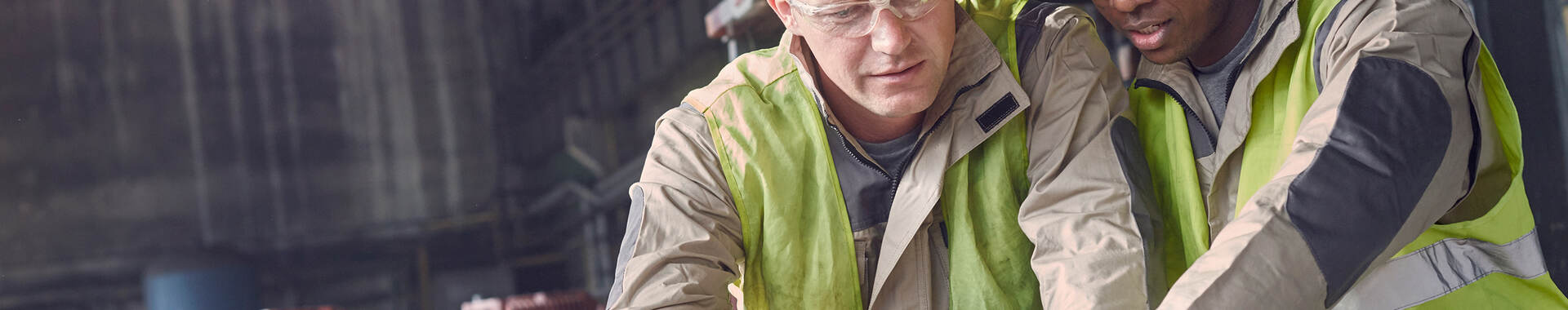 2 men in hard hats looking at laptop