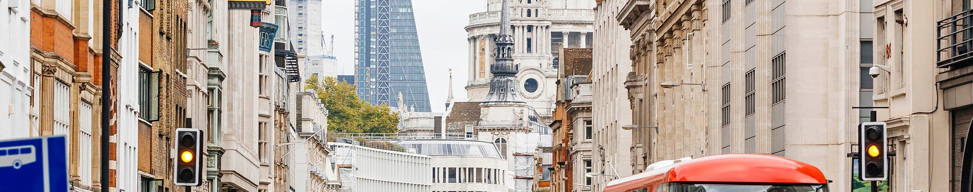 People walking on a busy street in London, England near St. Paul's Cathedral.