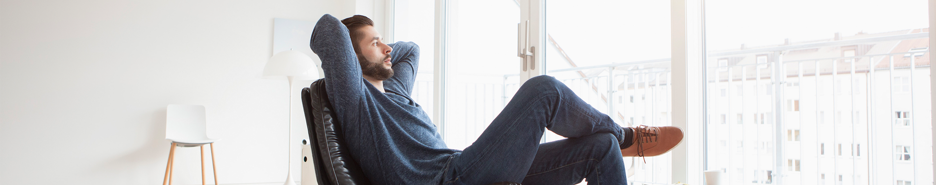 Man relaxing in an armchair conveying a sense of peace of mind, comfort and wellness.