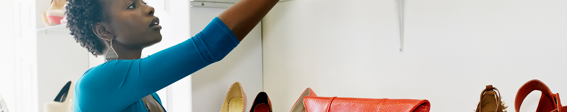 Woman reaching for a purse on a retail shelf