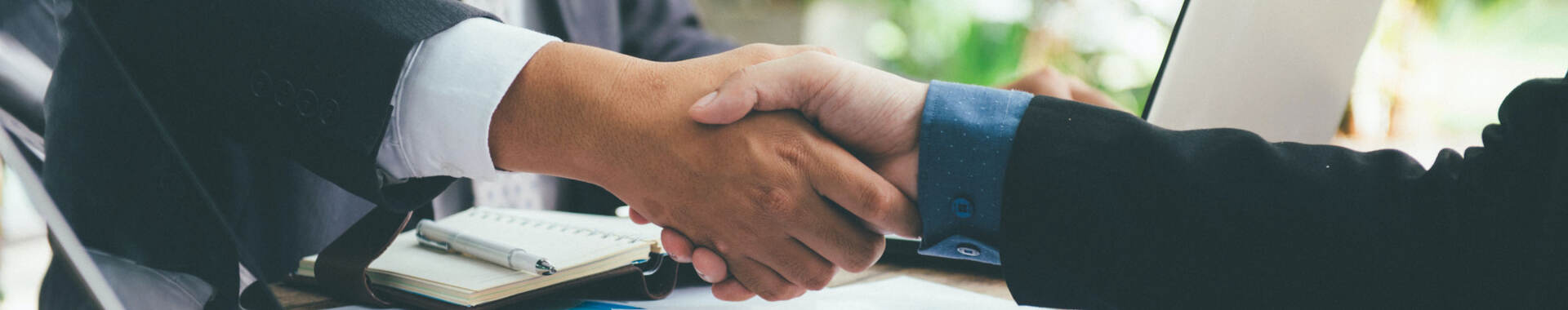 Business people shaking hands across a desk