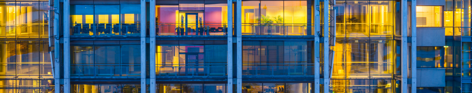 Business office building windows illuminated at dusk