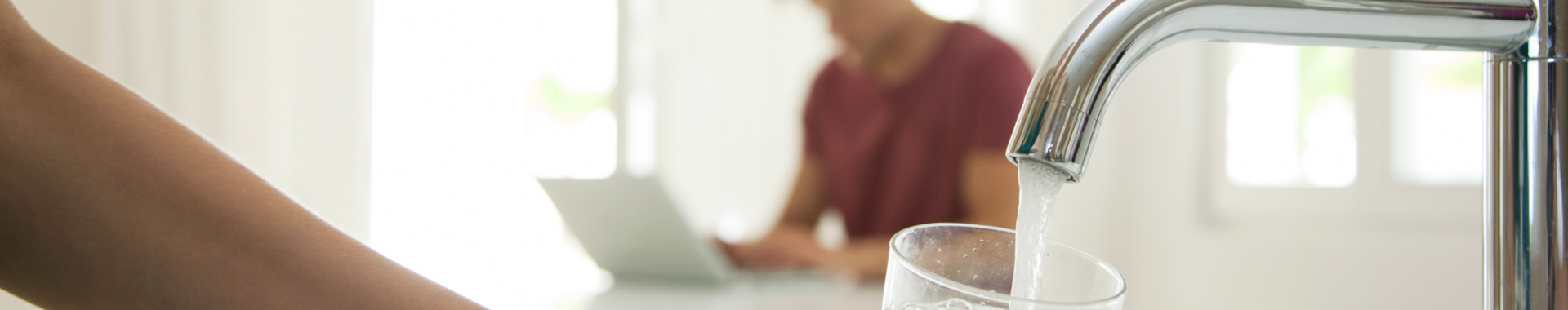 Person filling a glass with water