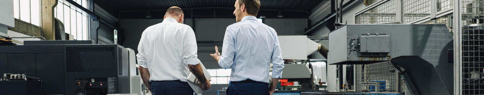 Two men walking and talking in a factory