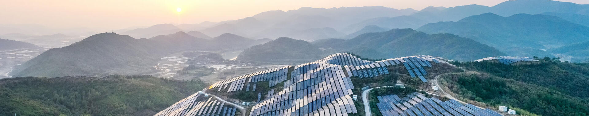 Aerial view of a solar power plant on top of a mountain.