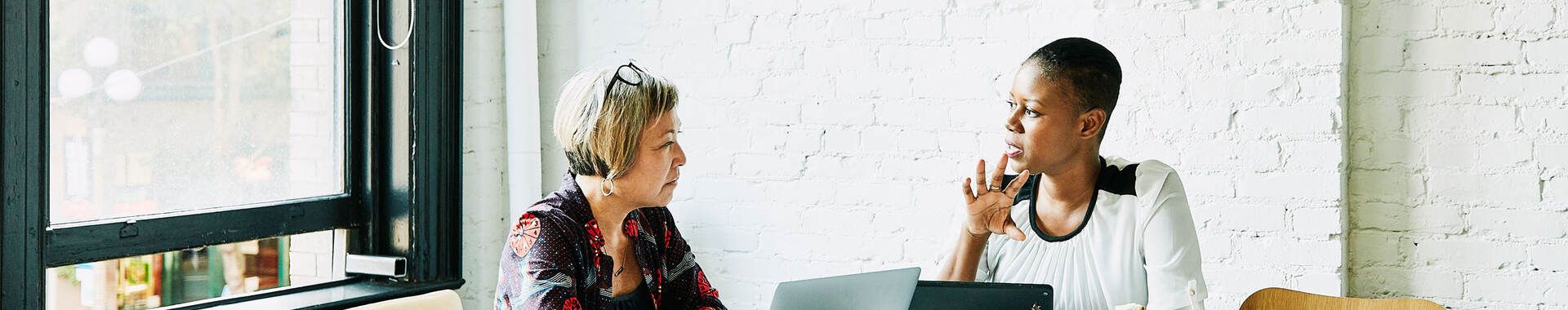 Two people sitting at a table discussing a topic