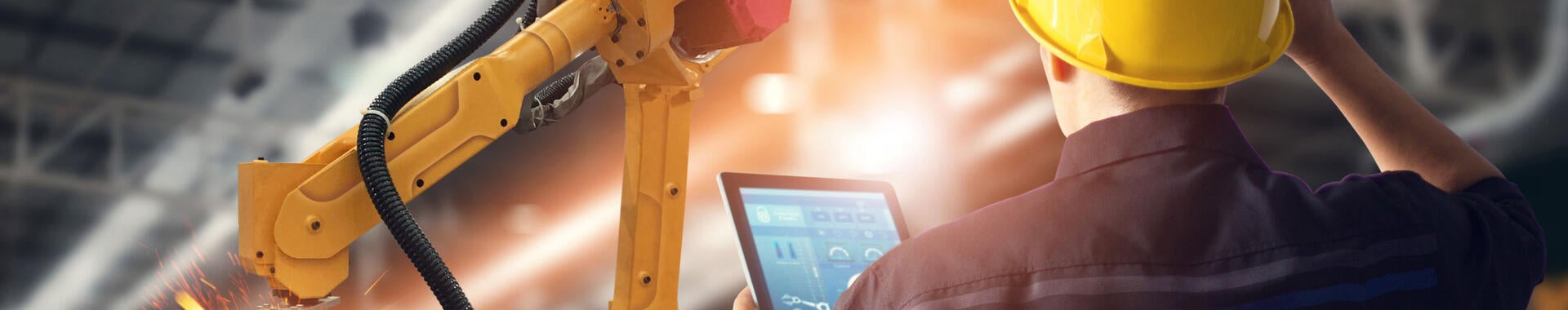 Worker overseeing automated machines in warehouse 