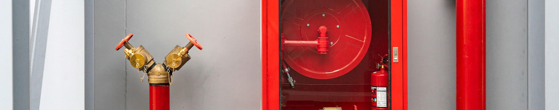 Fire extinguisher and fire hose reel in hotel corridor