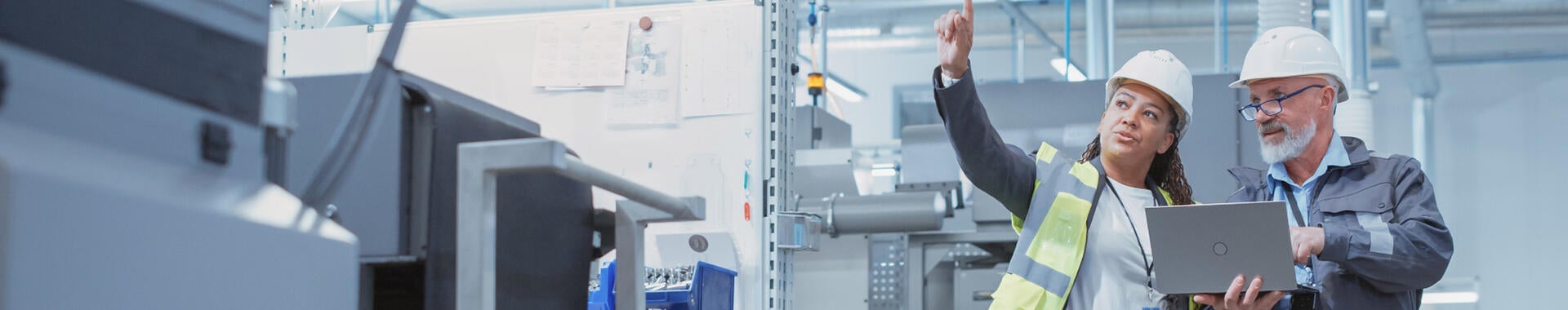 Two managers inspecting and discussing an industrial facility