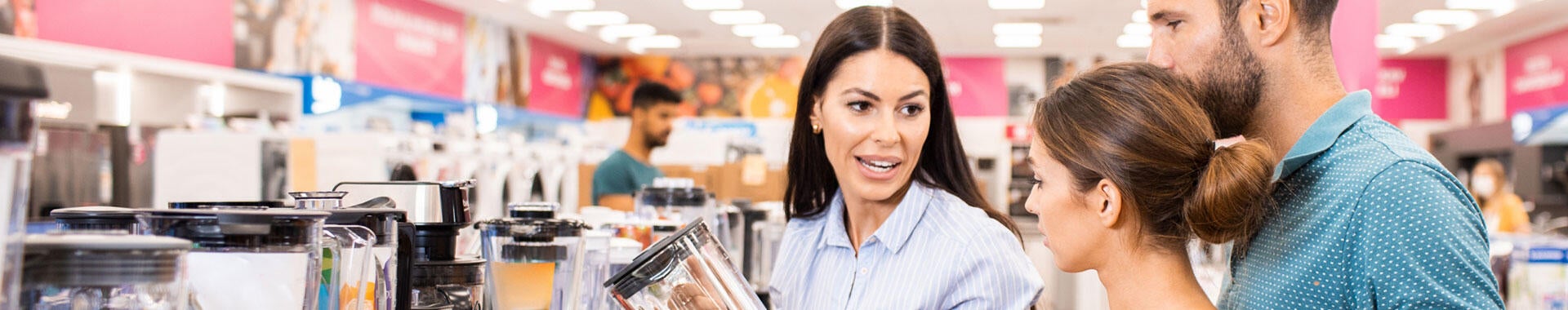 Three people looking at small appliances