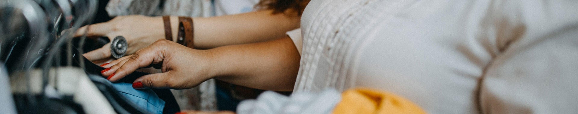 Two people looking through clothing on a rack