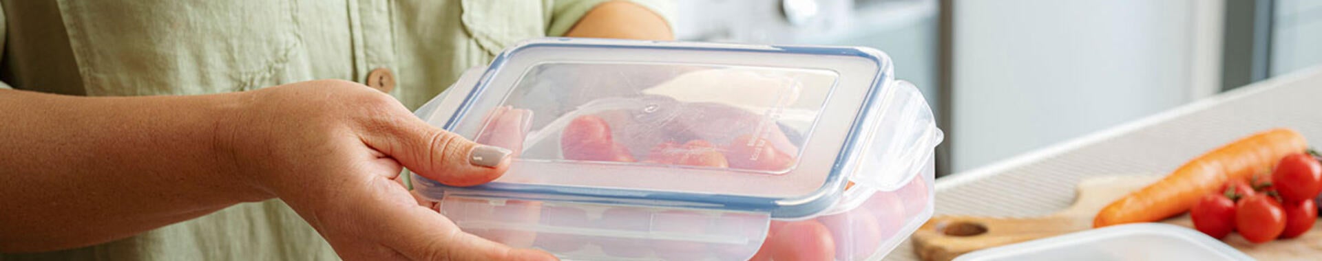 woman storing vegetables in glass container