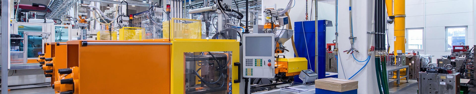 Orange and yellow machines in factory with motor