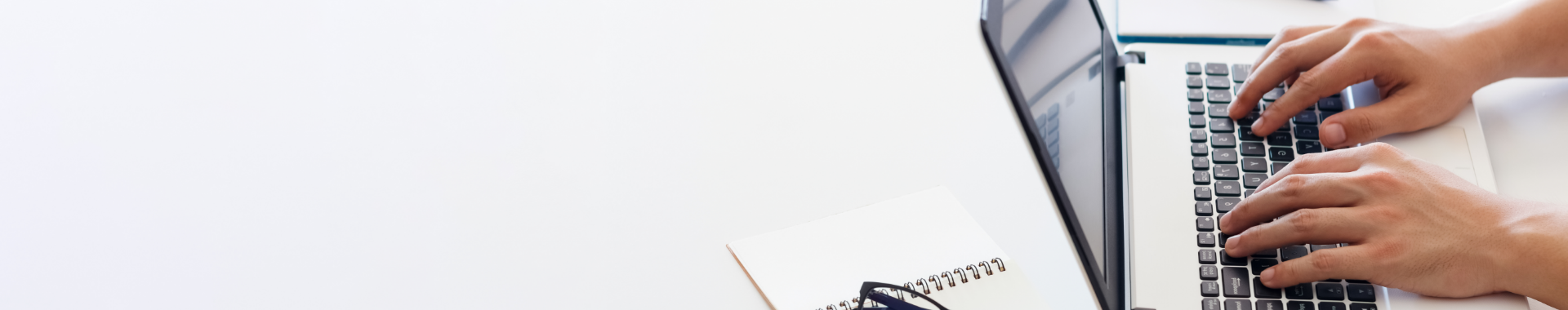 Bright image of a person typing on a laptop keyboard