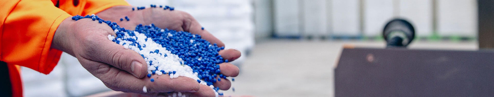 Hands pouring plastic pellets