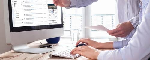 An office worker is being shown the new myUL portal on the computer.