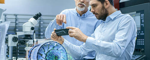 two male laboratory technicians observing a digital model