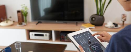 Woman controlling a smart home system with a tablet 