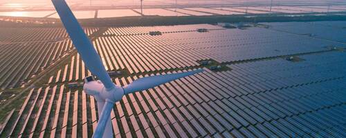 Wind turbines over a solar panel field