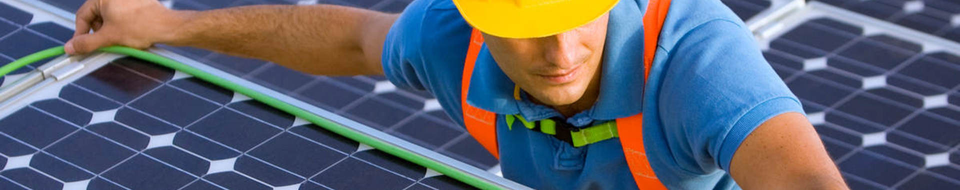 Man in hard hat doing wiring on a solar energy panel for wire and cable testing and certification