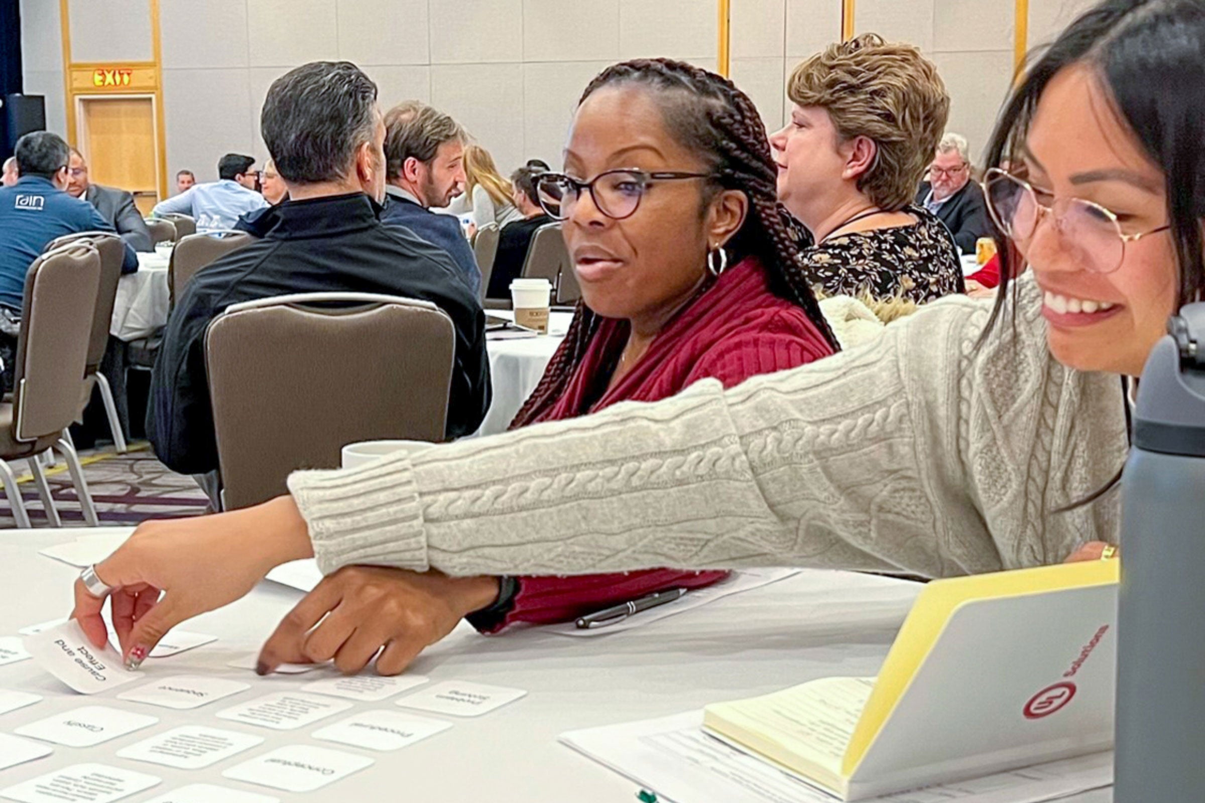 Conference attendees engage in a card game exercise during a presentation on instructional strategies.