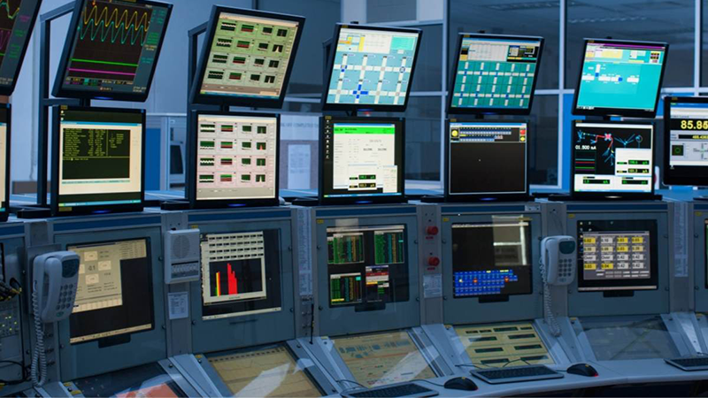 Several computer monitors lined up in a control room