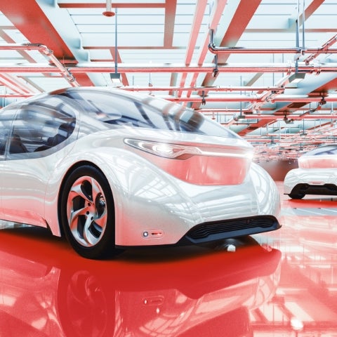 white futuristic car in large garage with red accents