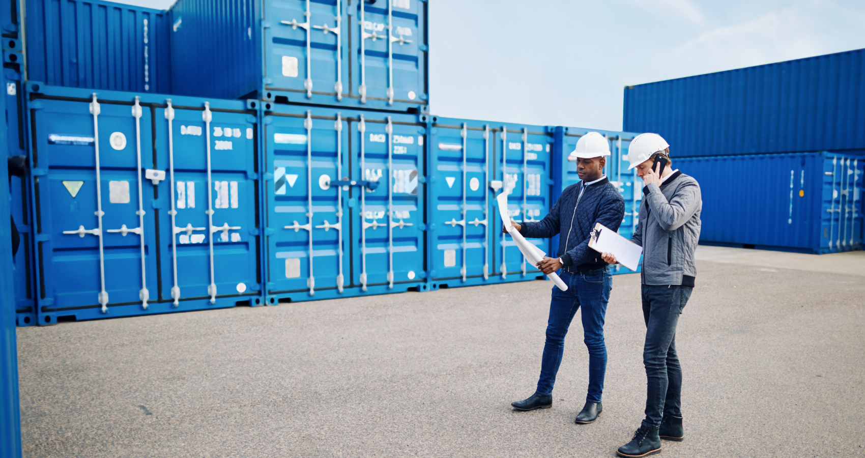 Workers next to shipping containers