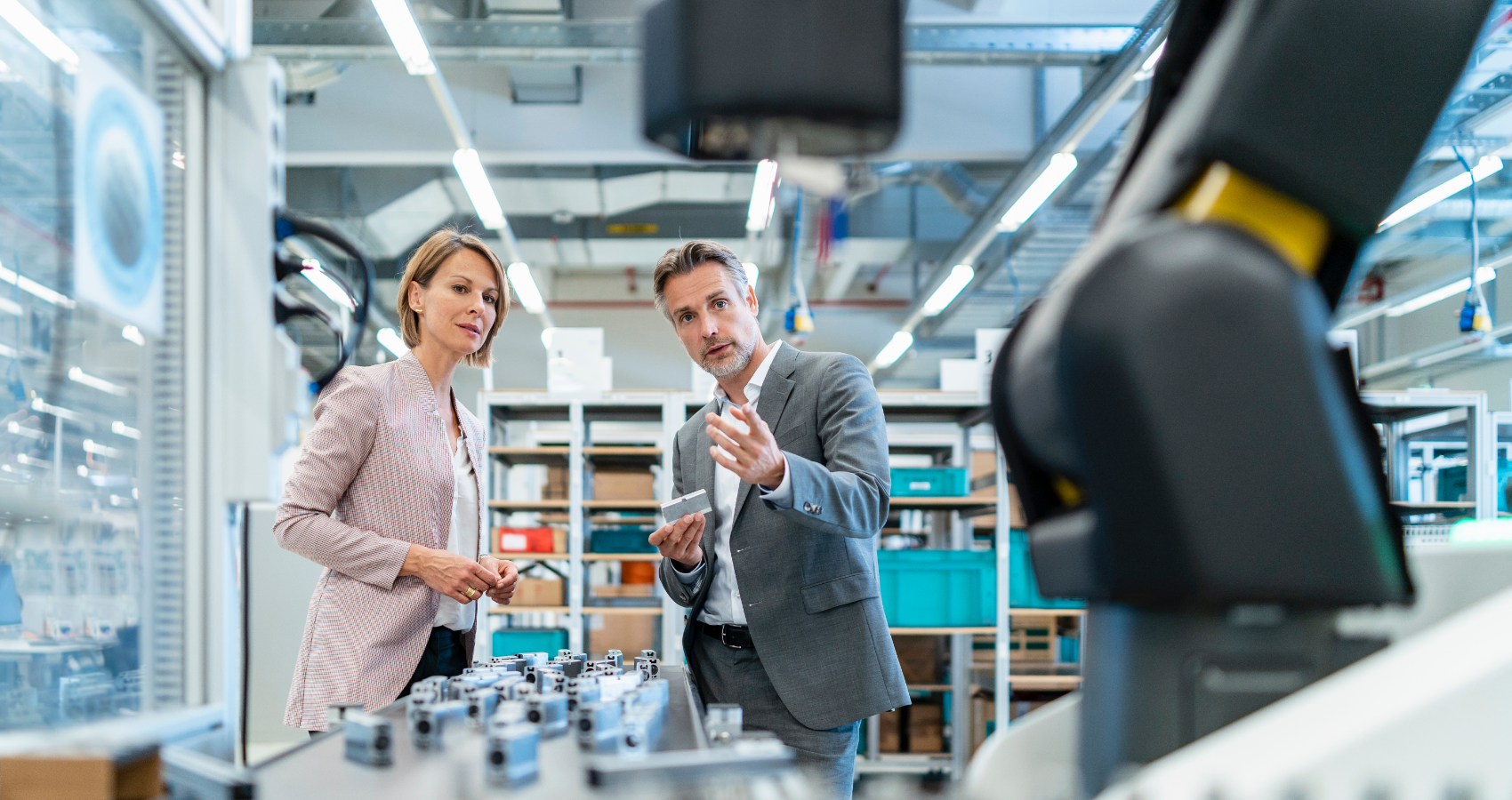 Workers talking next to a robot arm