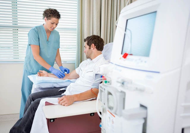 healthcare provider administering a medical test in front of medical equipment