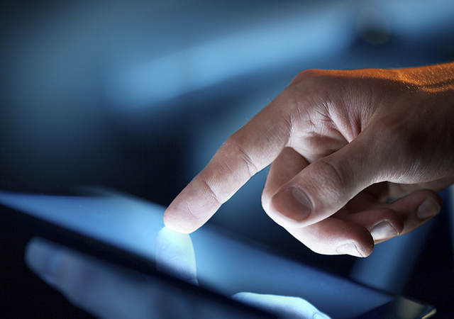 Finger pointing at illuminated tablet screen for TSCA Chemical Data Reporting webinar