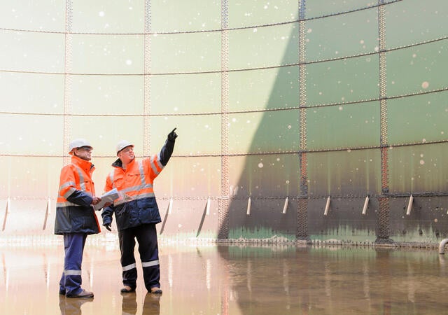 Technicians examining fuel storage tank