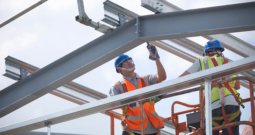 A construction worker laboring on a steel structure