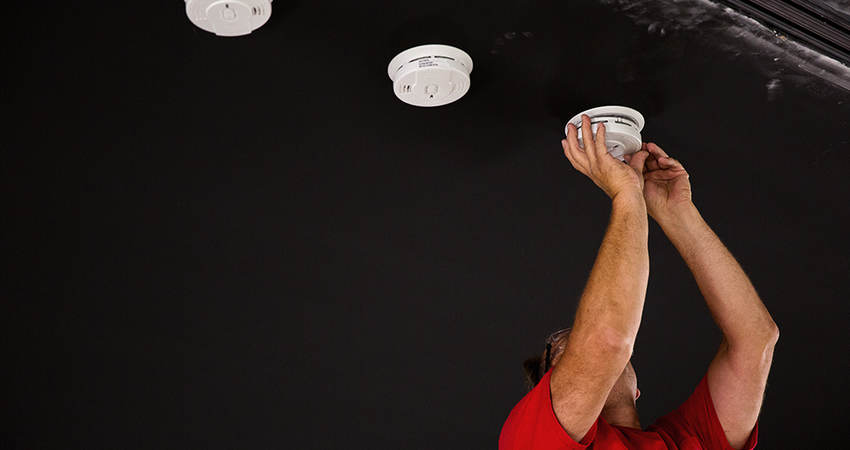 UL engineer installing smoke detectors for testing