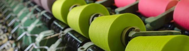 Textile industry - yarn spools on spinning machine in a textile factory