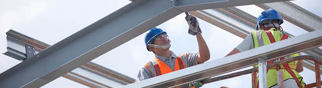 A construction worker laboring on a steel structure