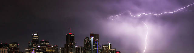 Nighttime skyline with lightning striking a building