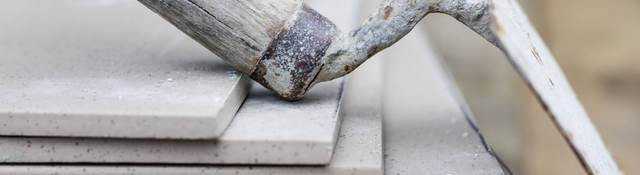 A trowel rests casually on a stack of cement tiles.