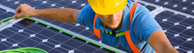man in hard hat doing wiring on a solar energy panel for wire and cable testing and certification