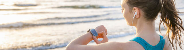 woman working out, looking at smartwatch