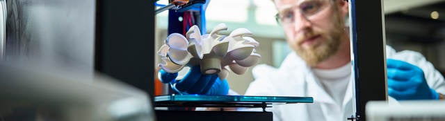 Photo of a scientist testing 3D printed plastic object